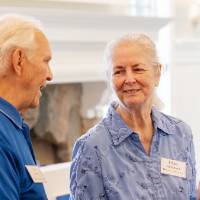 Diane Richmond grabbing food while looking over at Jim Scott